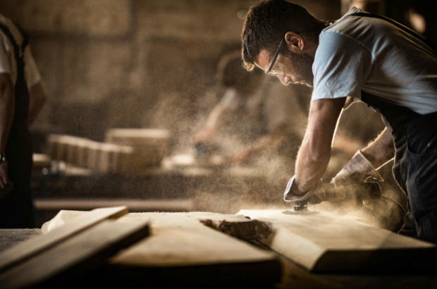 manual-worker-using-sander-while-working-on-a-wood-in-carpentry-workshop-stockpack-istock.jpg