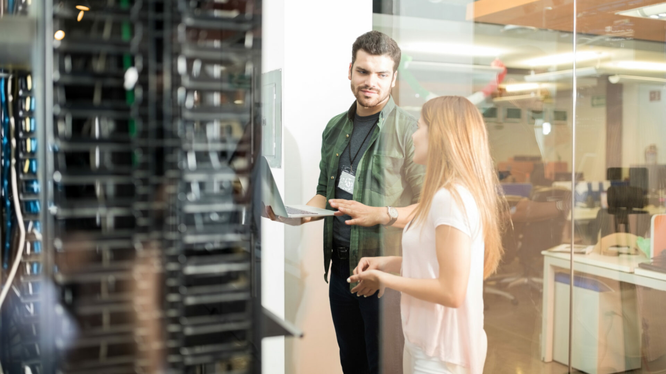 two-business-people-standing-in-server-room-with-laptop-and-discussing-stockpack-istock.jpg