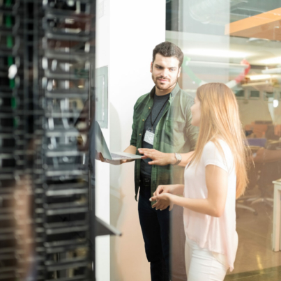 two-business-people-standing-in-server-room-with-laptop-and-discussing-stockpack-istock.jpg