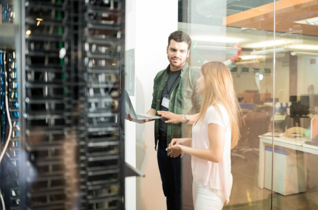 two-business-people-standing-in-server-room-with-laptop-and-discussing-stockpack-istock.jpg