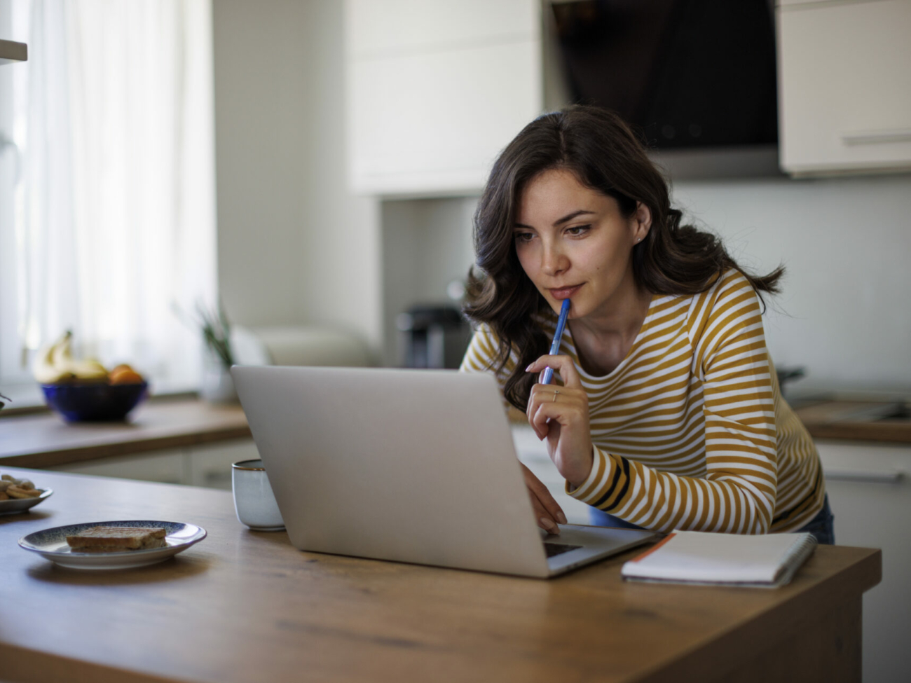 young-woman-using-a-laptop-while-working-from-home-stockpack-istock.jpg