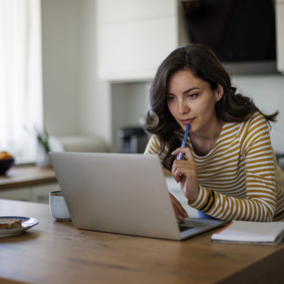 young-woman-using-a-laptop-while-working-from-home-stockpack-istock.jpg