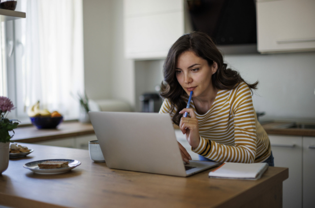 young-woman-using-a-laptop-while-working-from-home-stockpack-istock.jpg